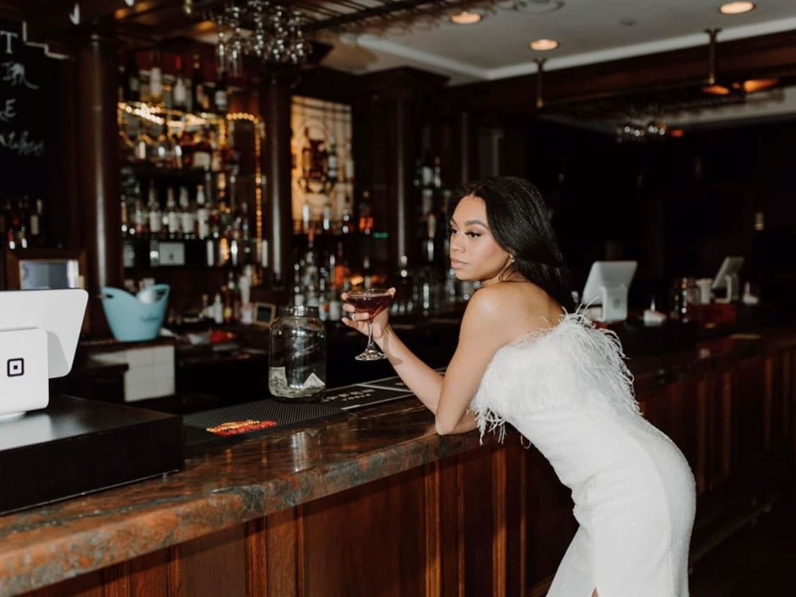 Woman enjoying a drink in Penthouse Rooftop Bar, The Mayo Hotel