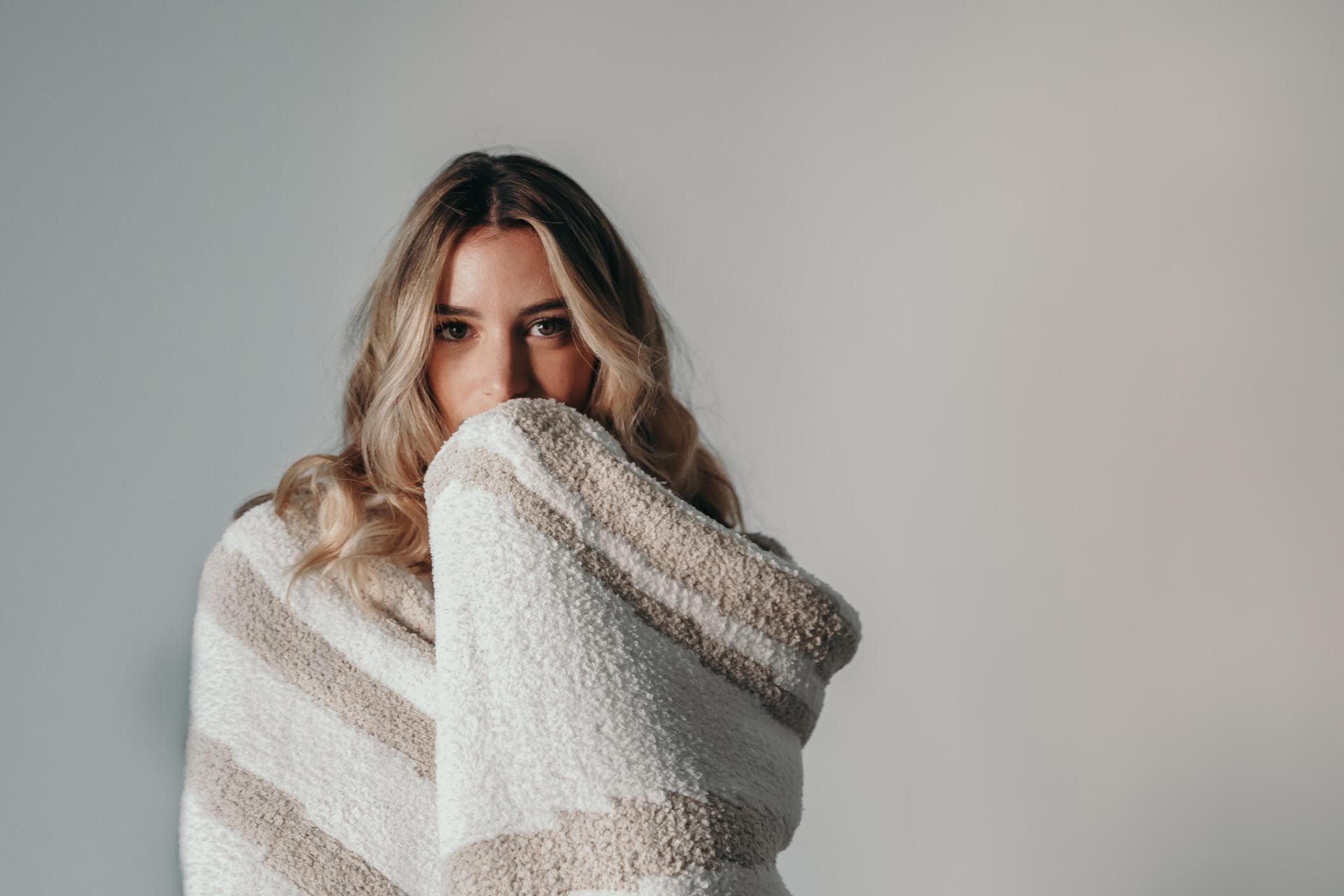 A lady covered up by a cozy blanket at Ivey's Hotel