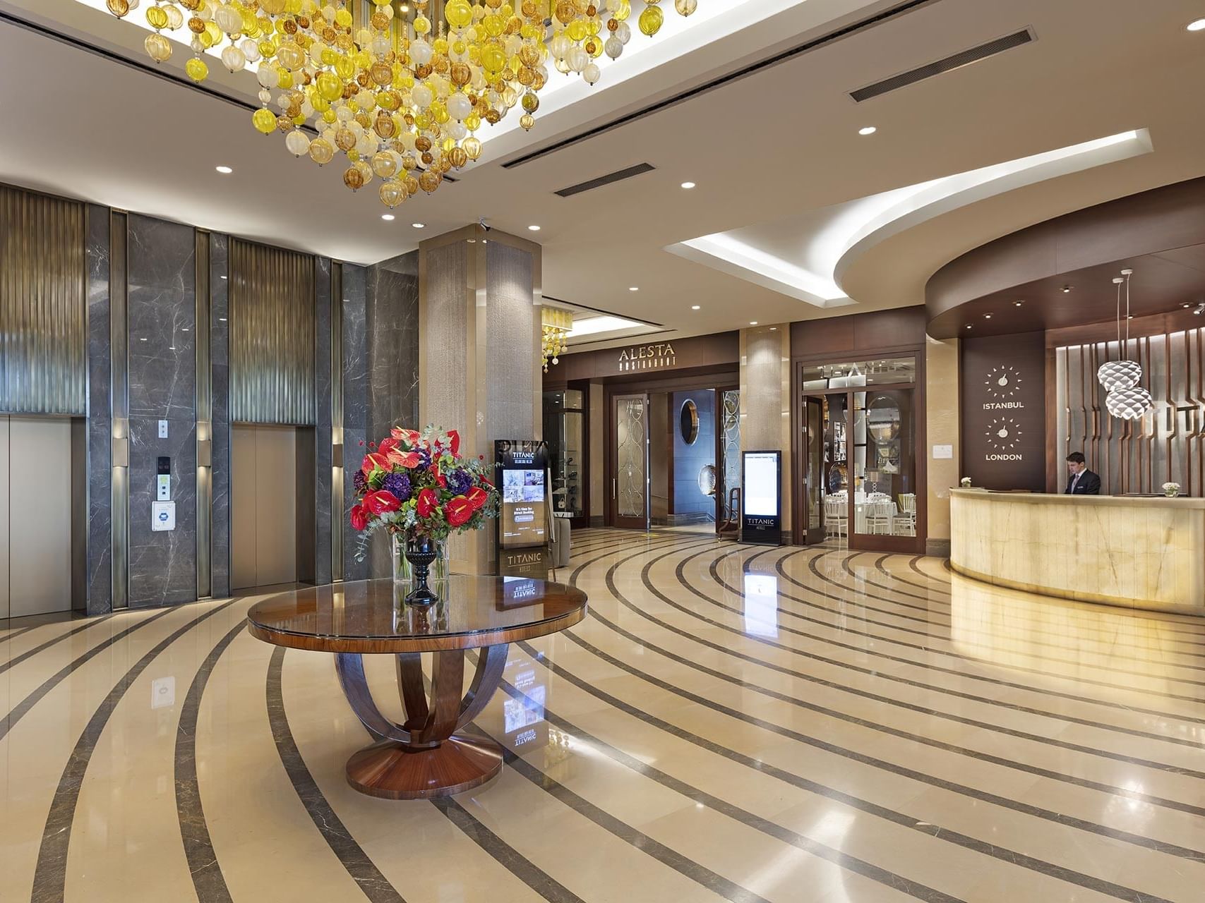 Titanic Business Kartal’ın lobi alanı, şık iç tasarımı, asansör bölümü ve modern resepsiyonuyla misafirlerine sıcak ve prestijli bir atmosfer sunuyor.
