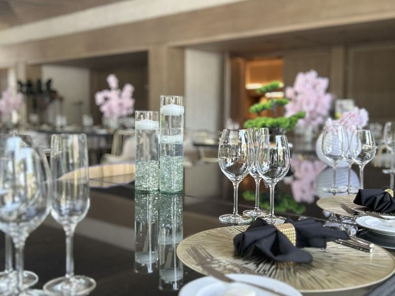 Decorated table with wine glasses and floral arrangements in Salón y Foyer Kioto at Grand Fiesta Americana Sumiya Cuernavaca.