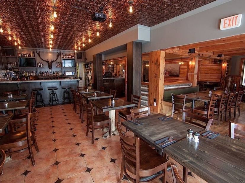 Dining table arranged by the bar counter area in Tavern 1883 Restaurant near Blackstone Mountain Lodge