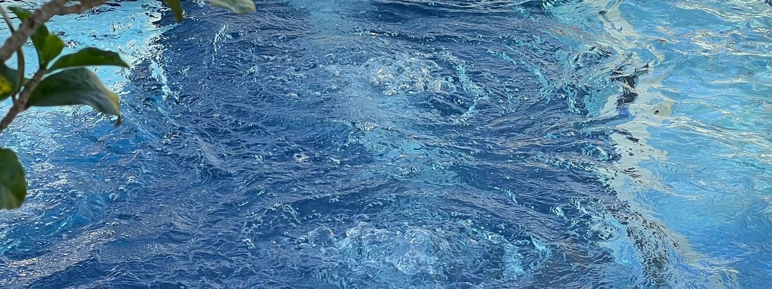 Bubbling blue water in a pool with tiled edges under green leaves at Warwick Le Lagon - Vanuatu, Efate