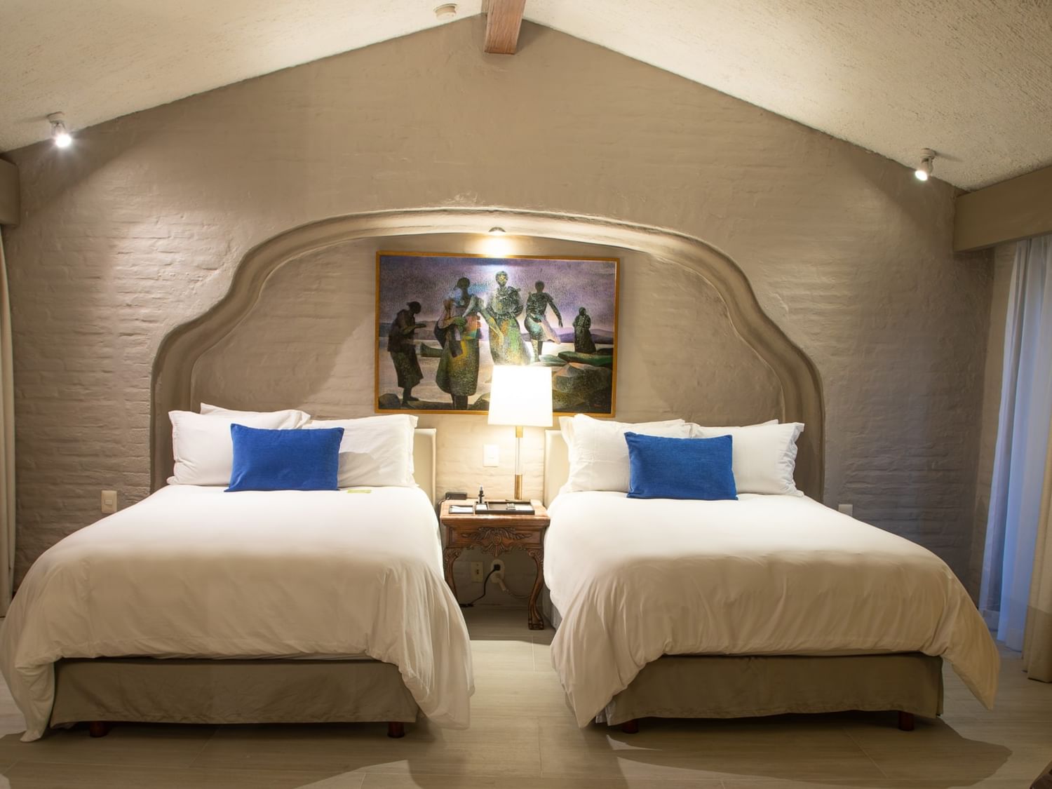 Suite Presidencial King con dos camas amplias, cabecera decorativa y cojines azules en Quinta Real Guadalajara