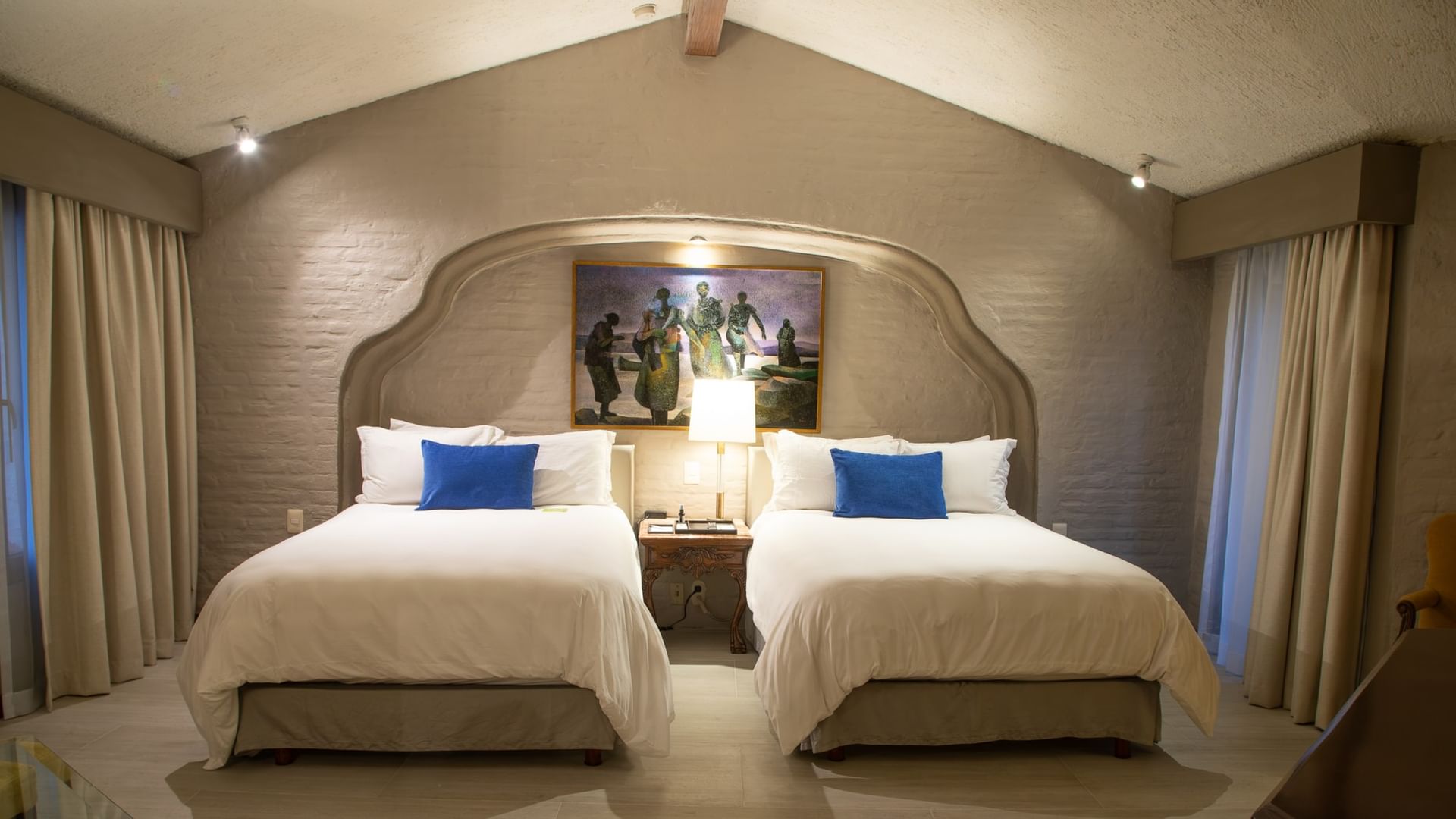 Suite Presidencial King con dos camas amplias, cabecera decorativa y cojines azules en Quinta Real Guadalajara