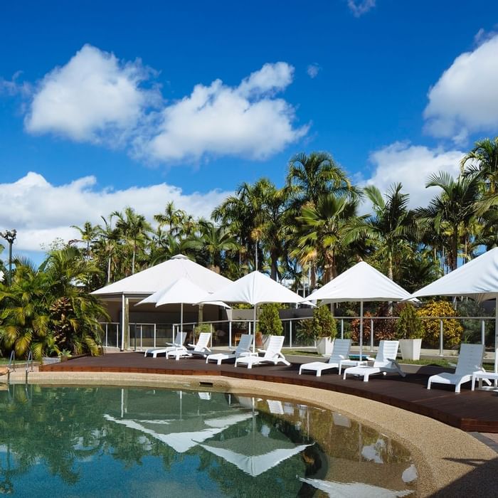 Outdoor large pool area with umbrellas and loungers at Mercure Townsville