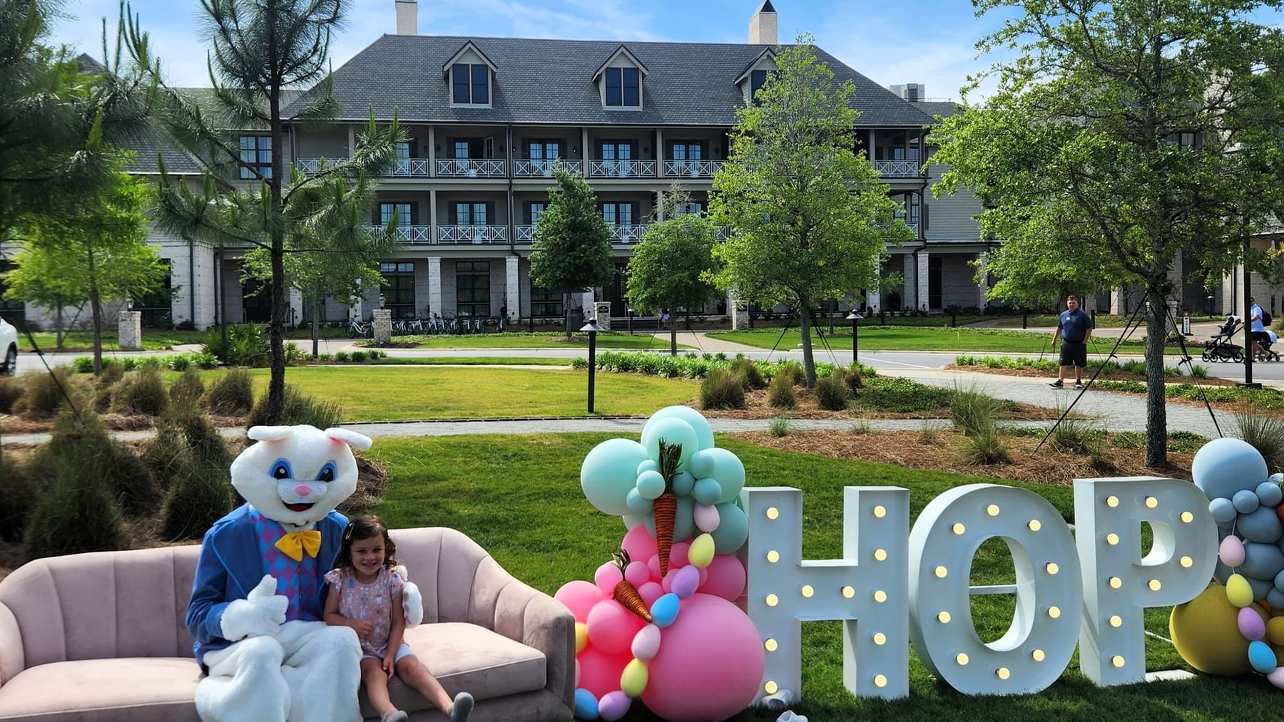 Easter setup with Easter Bunny, child, and decorative letters spelling HOP in the foreground.