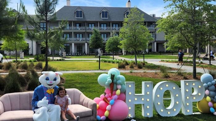 Easter Weekend at Camp Creek Inn with Easter bunny and child on couch and HOP sign.
