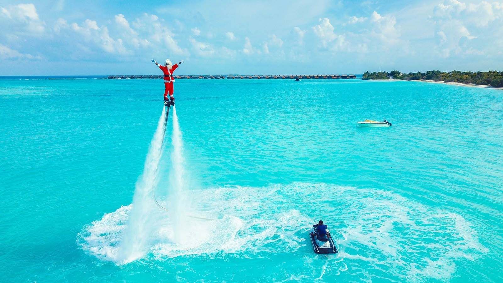 Santa flyboarding above the clear sea, The Signature Collection