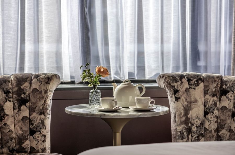 Tea service with a white teapot and cups placed on a marble table at The Capital Hotel, Apartments and Townhouse
