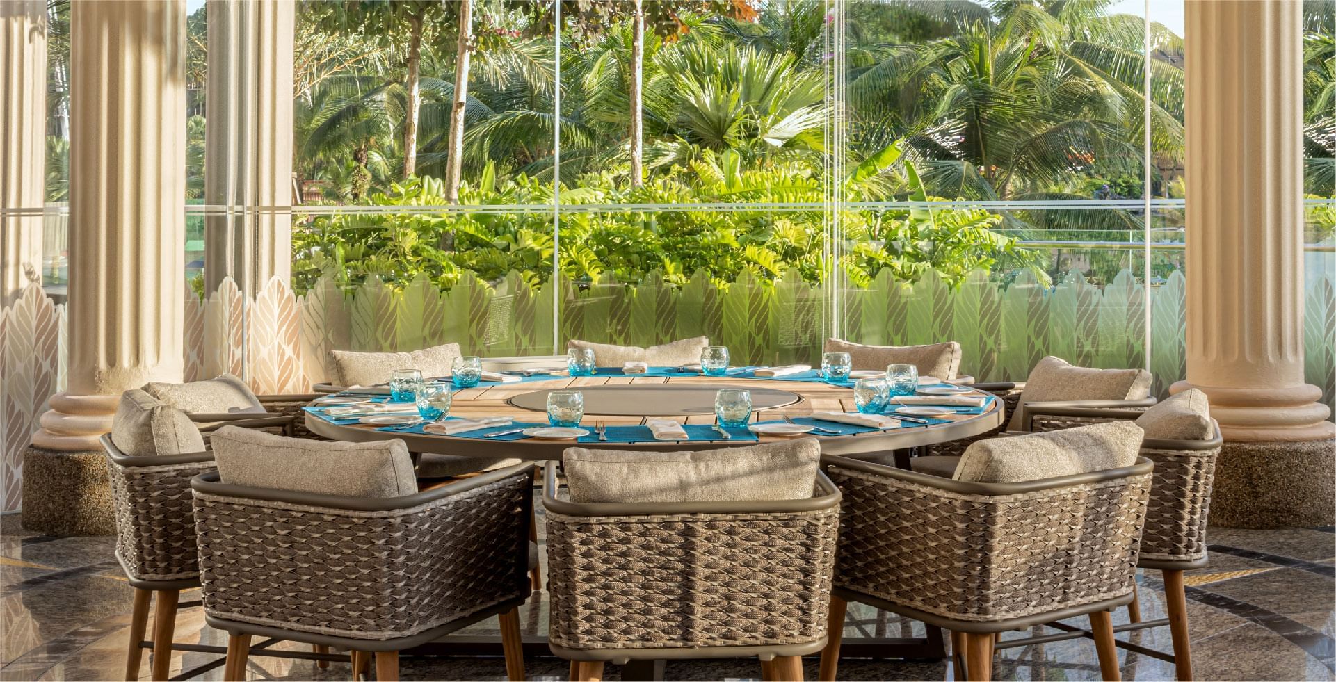 A large family-style table with elegant place settings, surrounded by lush greenery, at Sunway Resort