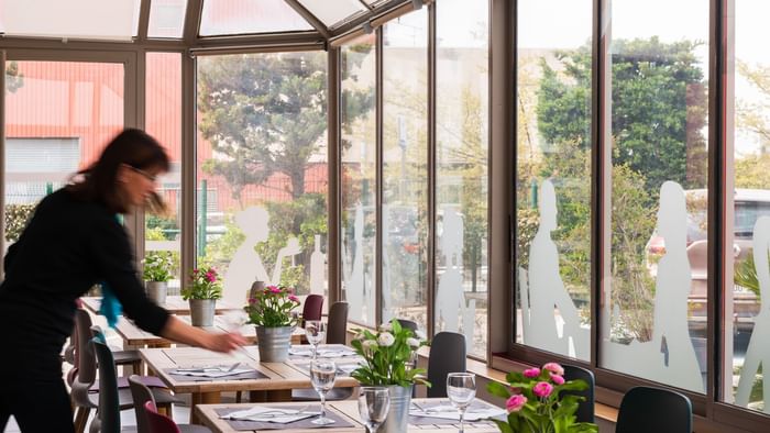 Woman prepare table in dining area at hotel marseille airport