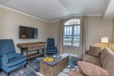 A stylish living room in a suite at The Stanley Hotel, with a large window and a view of the mountains