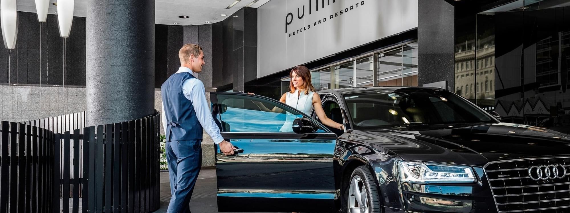 Concierge opening the door for a lady at Pullman & Mercure Brisbane King George Square