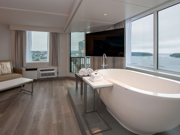 Modern suite with a large soaker tub, balcony, and city view at Coast Bastion Hotel in Nanaimo.