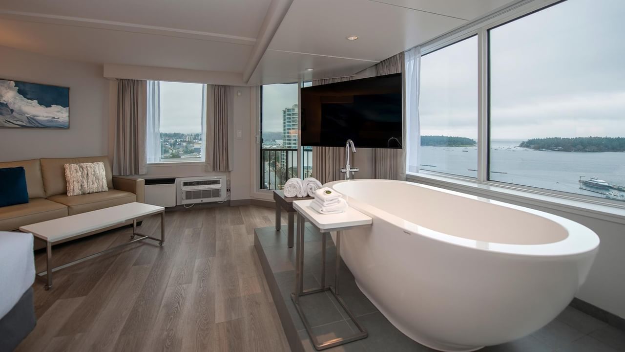 Modern suite with a large soaker tub, balcony, and city view at Coast Bastion Hotel in Nanaimo.