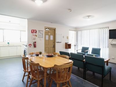 A communal kitchen and dining area with a table, chairs, and appliances at Vickery House.