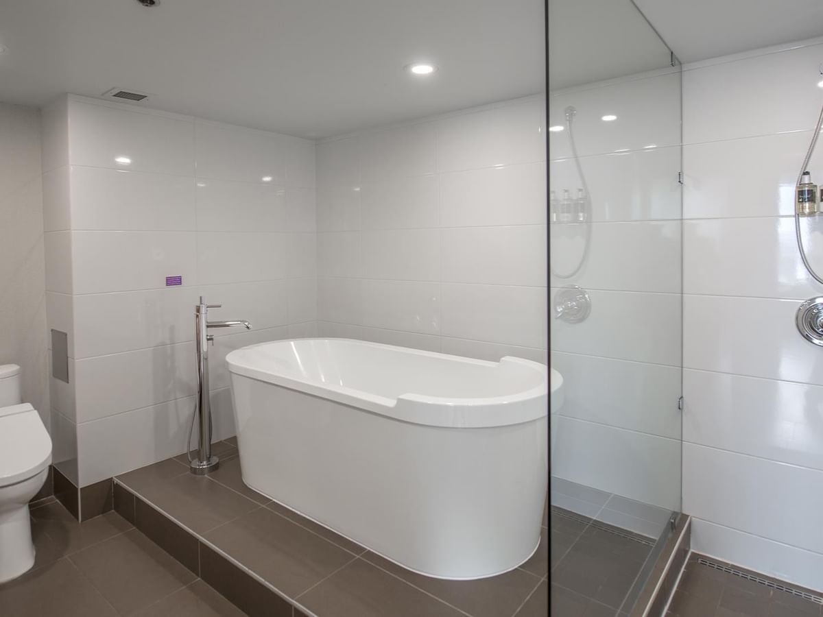 Modern bathroom with a bathtub, toilet, and shower.