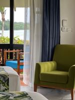 Green chair and beds with tropical print at Warwick Le Lagon - Vanuatu, Efate.