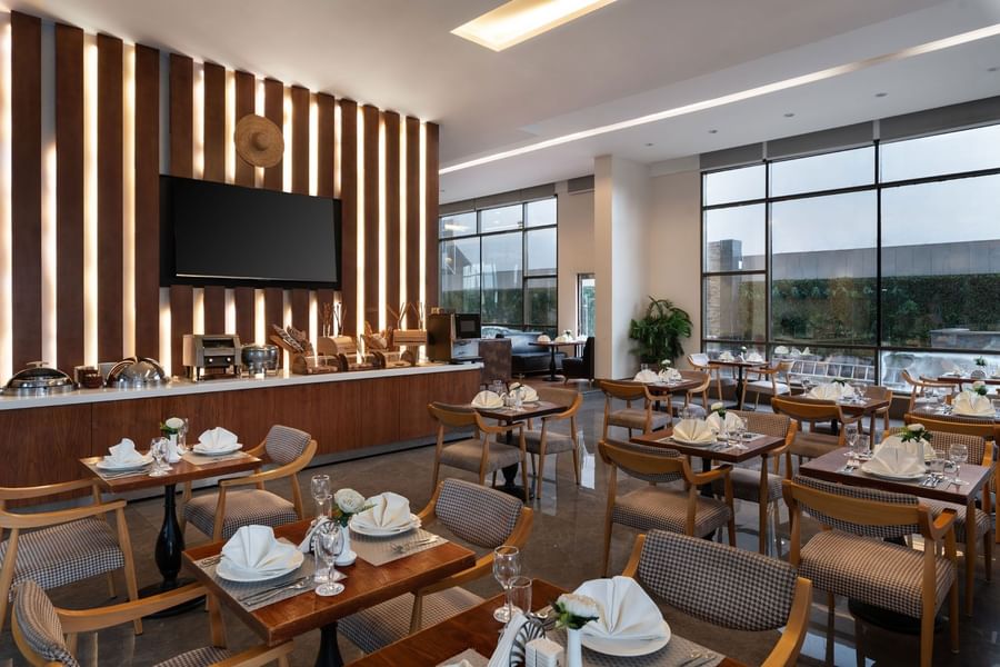 Seasons Restaurant dining area with elegant wooden furniture and patterned chairs at Warwick Hotel Jeddah