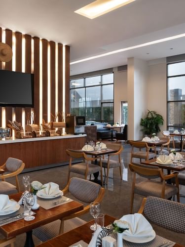 Seasons Restaurant dining area with elegant wooden furniture and patterned chairs at Warwick Hotel Jeddah
