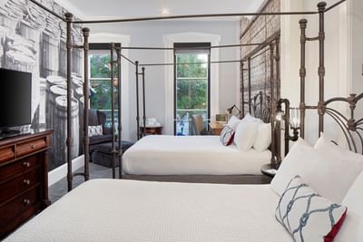 TV & work desk facing beds in Historic City View with Two Queens Room at River Street Inn