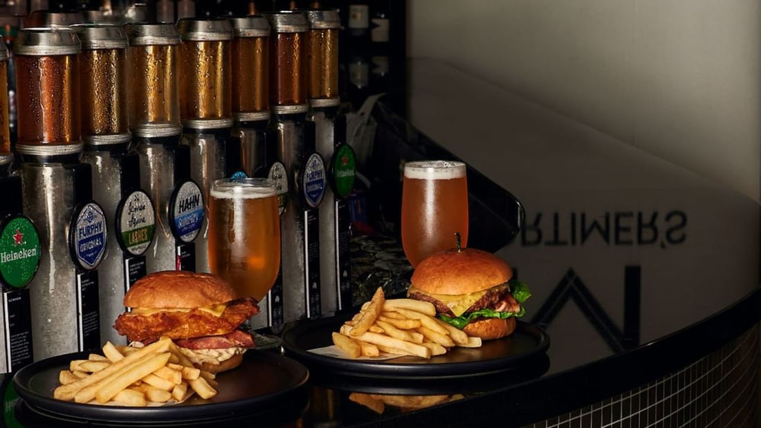 Burgers and fries served with beer glasses in a restaurant at Pullman Albert Park