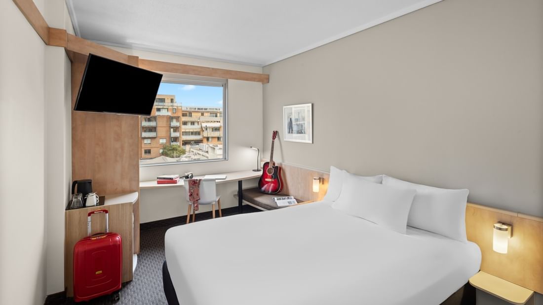 Standard room with one queen bed, work desk, wall-mounted TV, and city view at Ibis Sydney Darling Harbour in Pyrmont