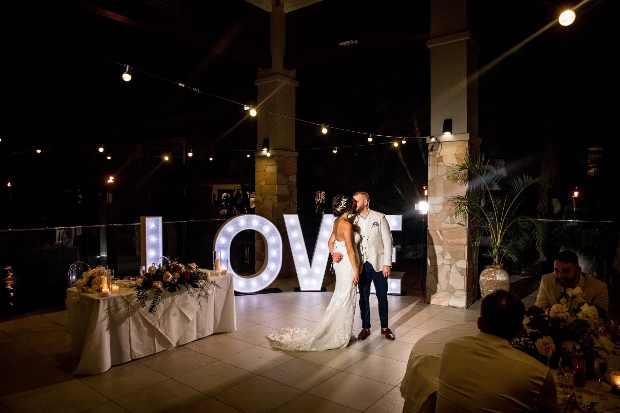 Wedded couple dancing by illuminated 'LOVE' sign in Four Mile Beach at Pullman Port Douglas Sea Temple Resort & Spa