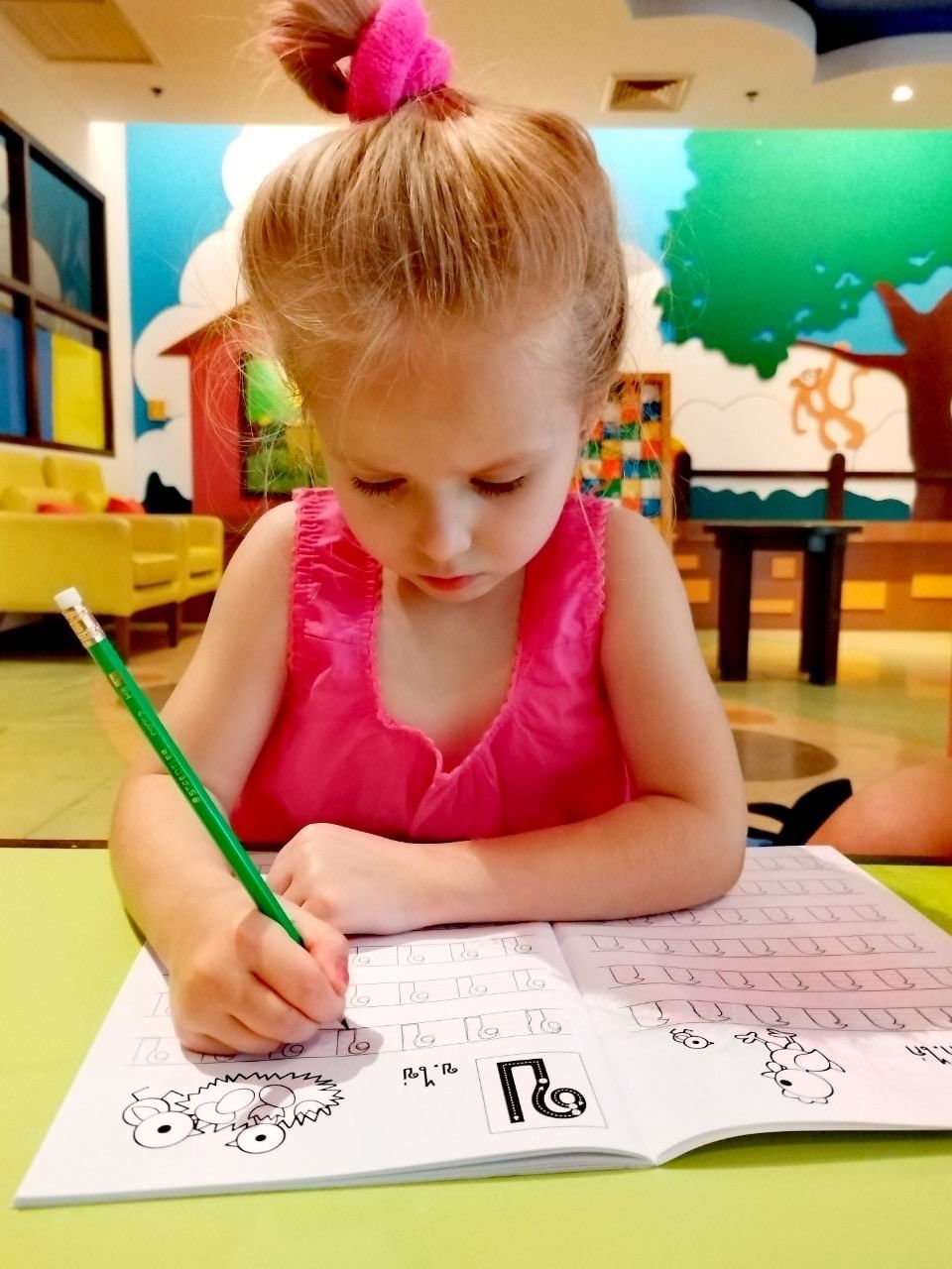 A girl, wearing a Thai traditional costume, is attending Thai language class at kids club at Paradox Resort Phuket