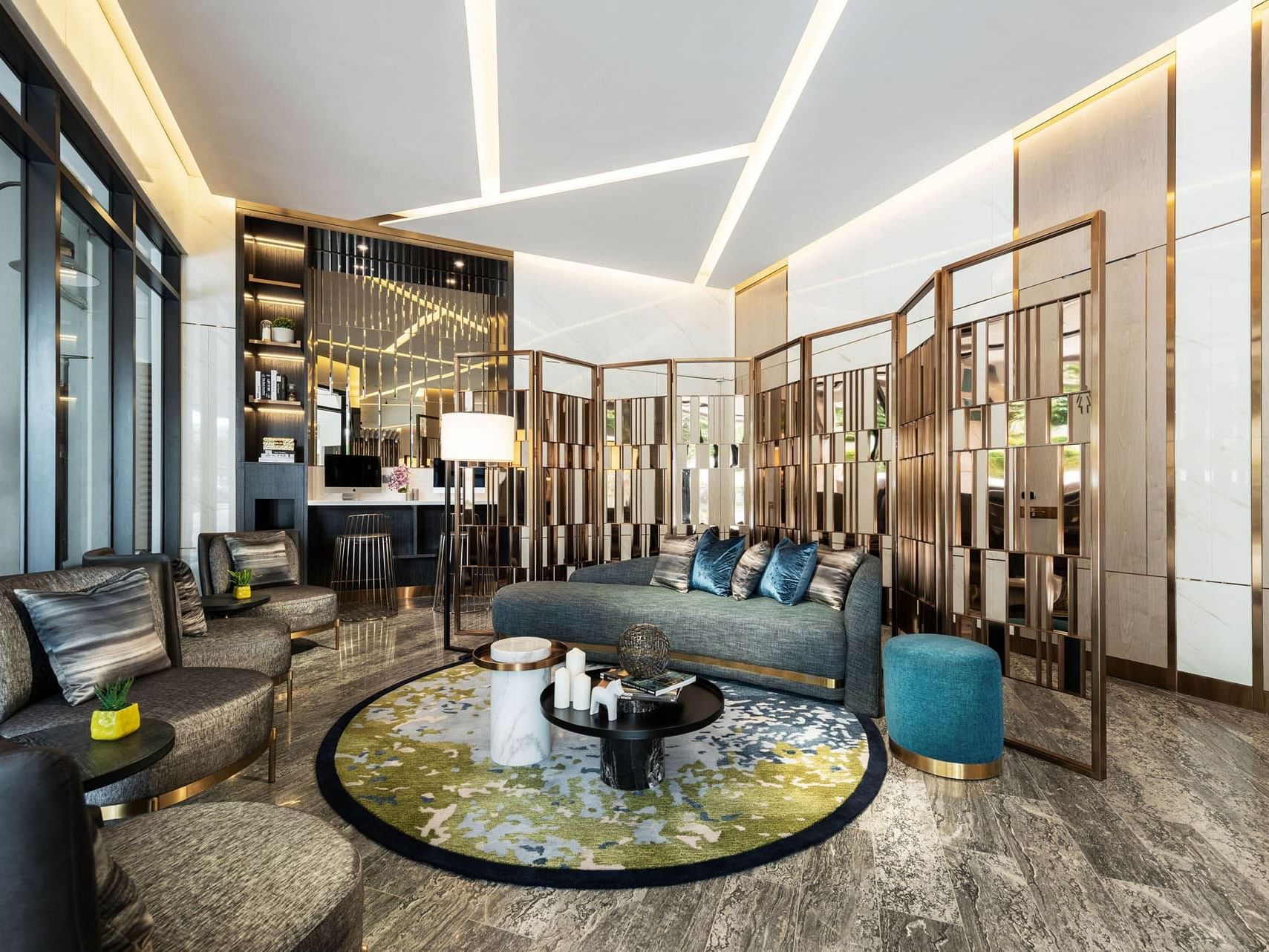 Modern lobby with sleek furniture, circular rug, decorative partitions, and warm lighting at Orchard Grand Court