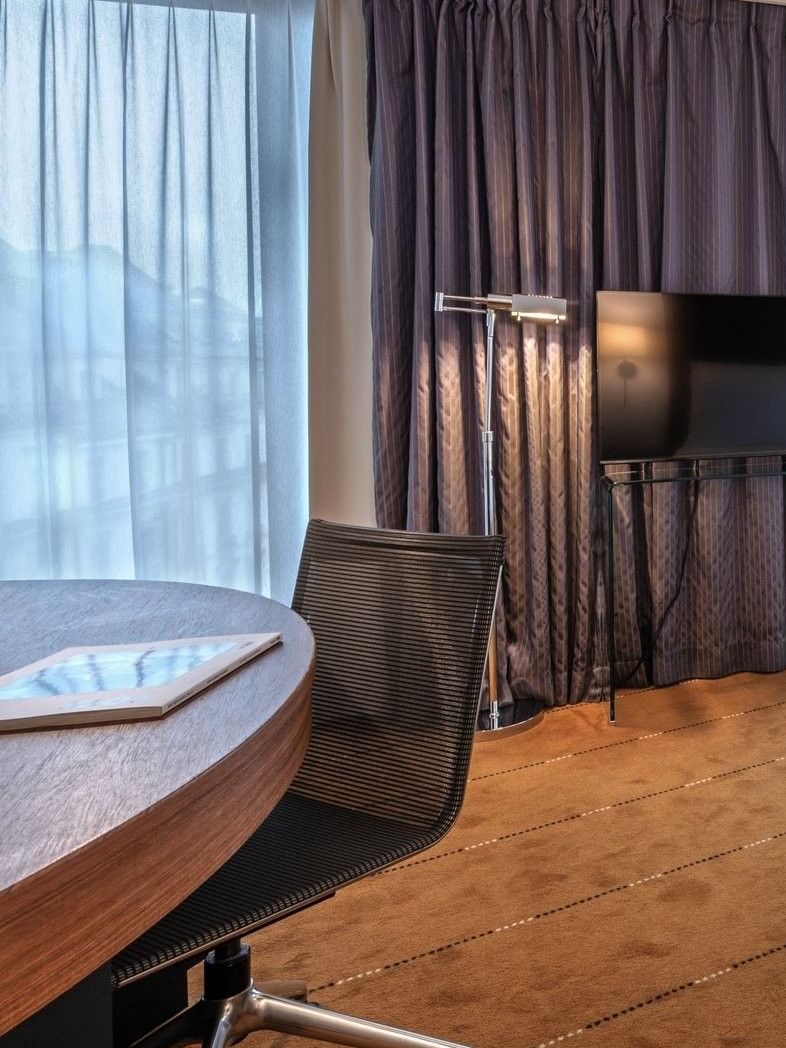 Chambre Supérieure avec lit, bureau, chaise et télévision à l'hôtel Warwick Geneva à Genève.