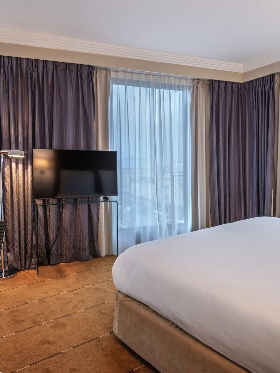 Chambre Supérieure avec grand lit, bureau et télévision à l'hôtel Warwick Geneva à Genève.
