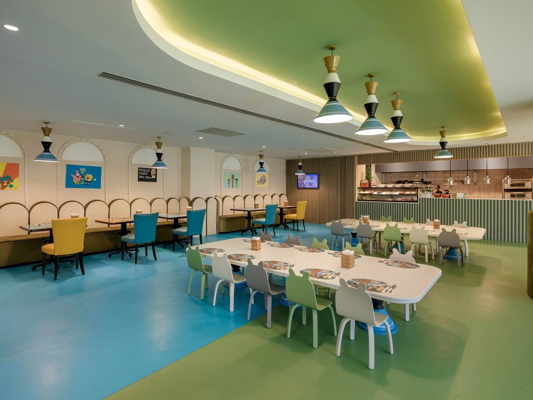 Colorful children's dining area with white tables, green chairs, and decorative pendant lights at Titanic Deluxe Golf Belek