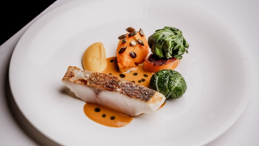 Pan-seared fish fillet with vegetables served in Tom Brown at The Capital at The Capital Hotel, Apartments and Townhouse