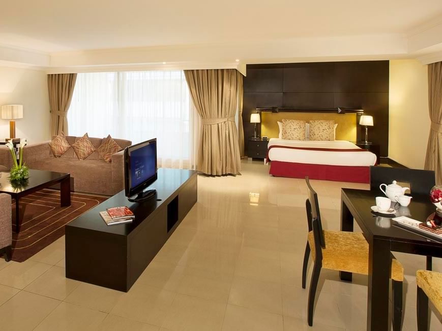 Bed and living area in Family Suite at City Seasons Hotels