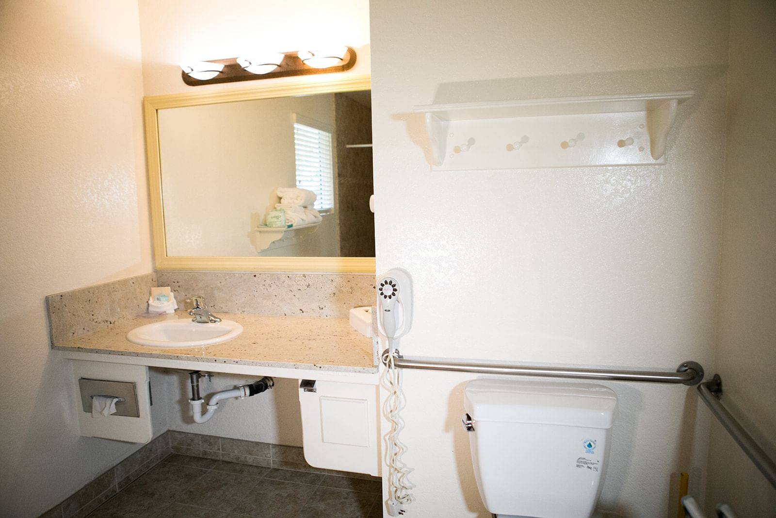 A bathroom with a sink, toilet, and grab bars.