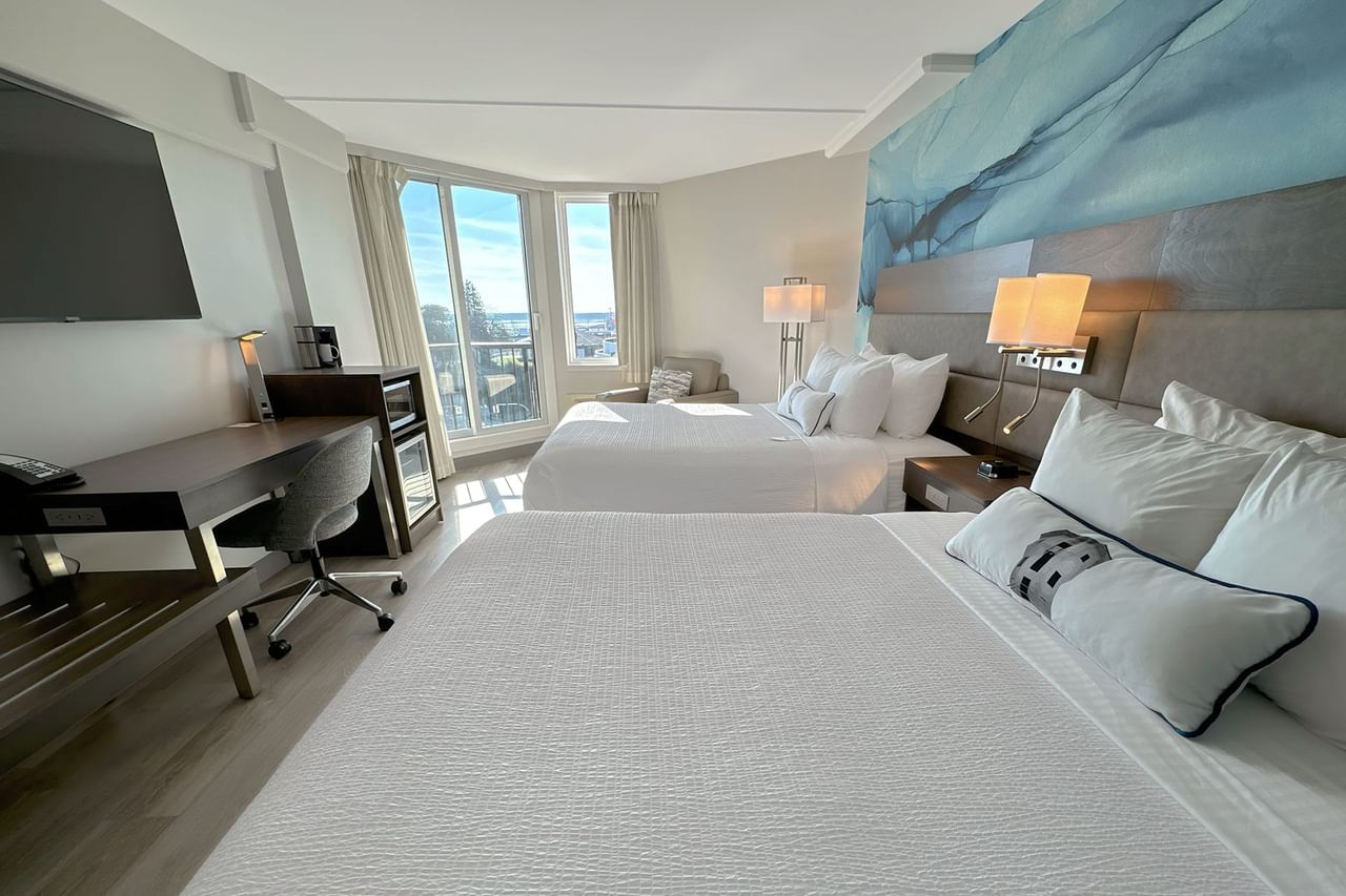 Hotel guestroom with two queen beds and a blue wall mural
