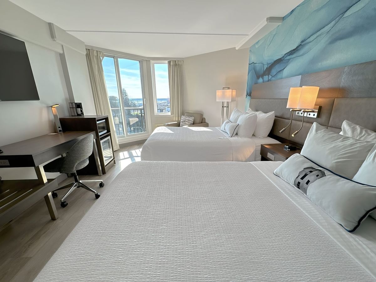 Hotel guestroom with two queen beds and a blue wall mural