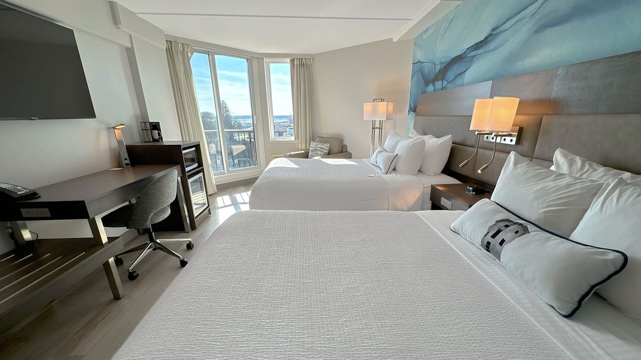 Hotel guestroom with two queen beds and a blue wall mural