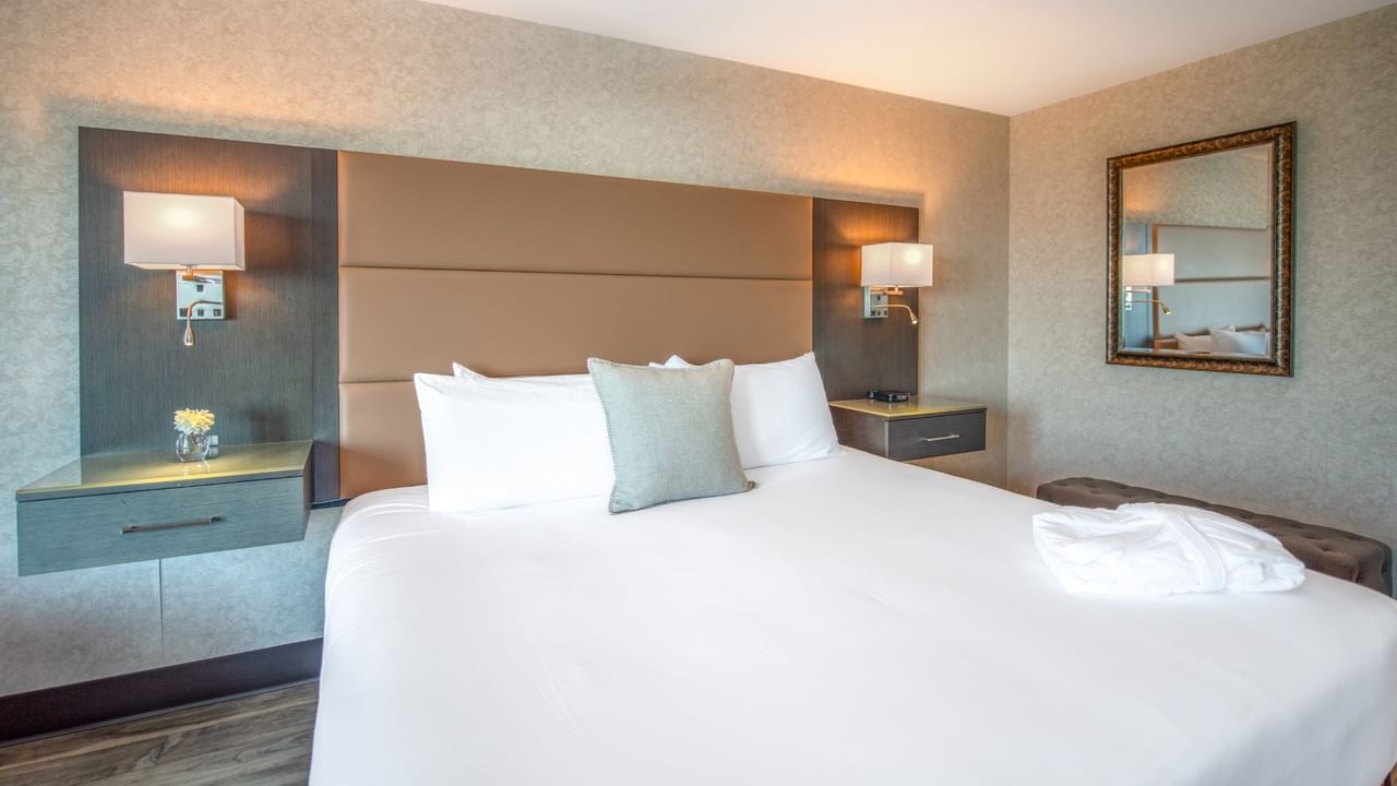 Coast Premium King with a large bed, nightstands, wall-mounted lamps, and a mirror at Coast Lonsdale Quay Hotel
