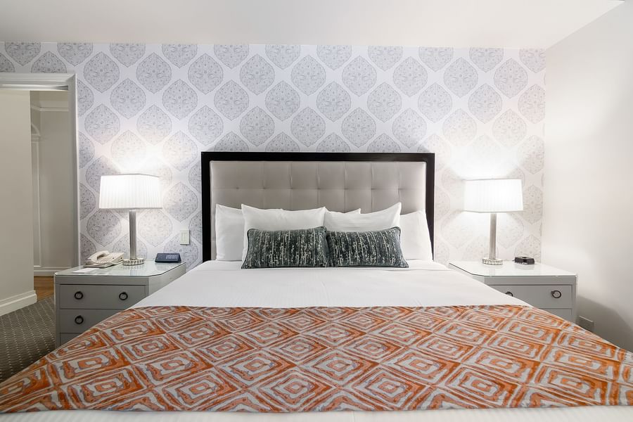 Bed between side lamps with patterned accent wall in Premier Room at Warwick New York