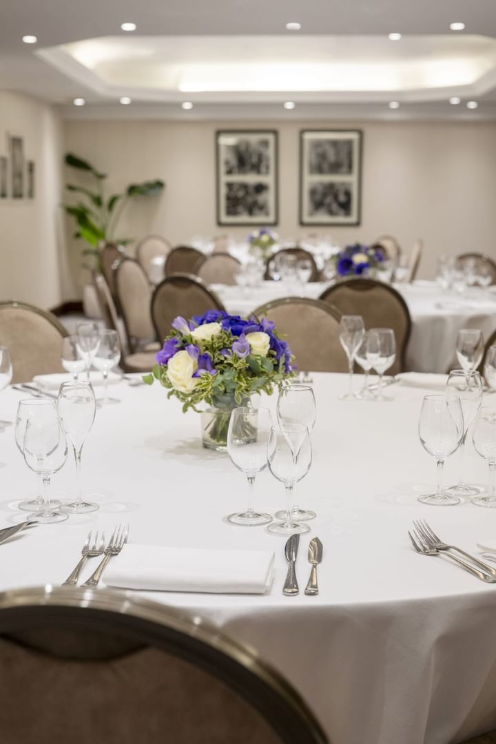Banquet tables with blue and white floral centerpieces set at Restaurant, Bar & Terrace Le W, an elite Restaurant in Paris