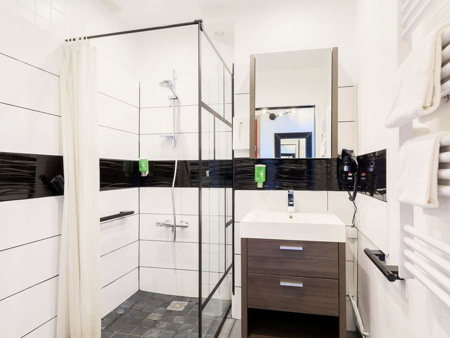 A bathroom with curbless shower, vanity, at Hôtel de l'Europe