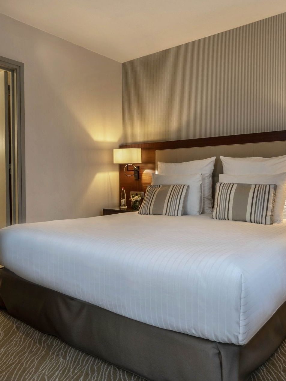 Bed between the side tables near the doorway to the bathroom in Junior Suite Privilege View at Warwick Grand Place Brussels