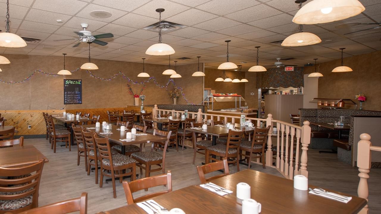 dining room with tables, chairs and pendant lights at Green Gables Restaurant & Lounge