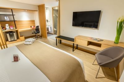 A room with one king bed and other room amenities