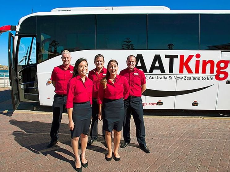Employees of AAT Kings in front of a bus near H On Smith Hotel