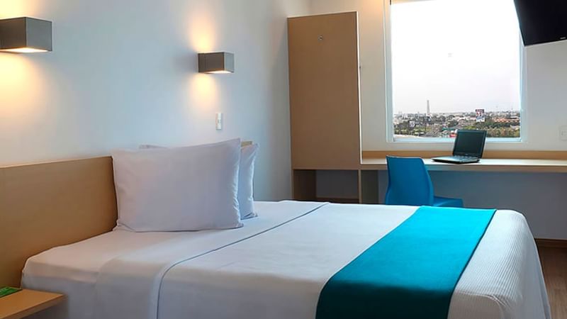 Cozy bed arranged with pillows at One Hotels