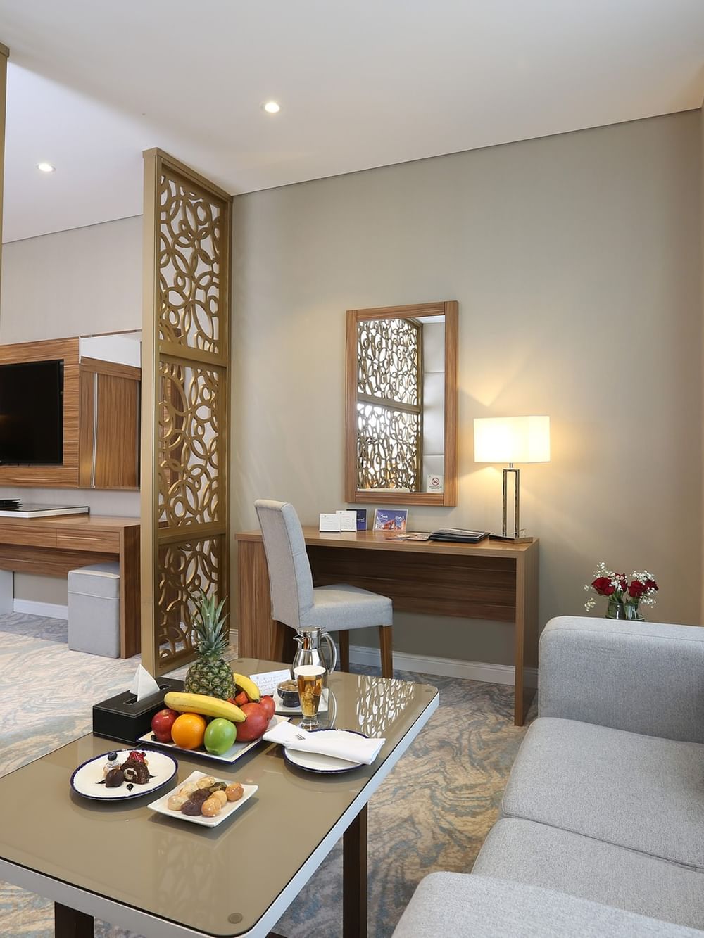 Cozy Junior Suite with fruit plate and couch at Cantonal Hotel by Warwick Riyadh.