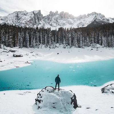 A man standing on snow covered stone near Falkensteiner Hotels